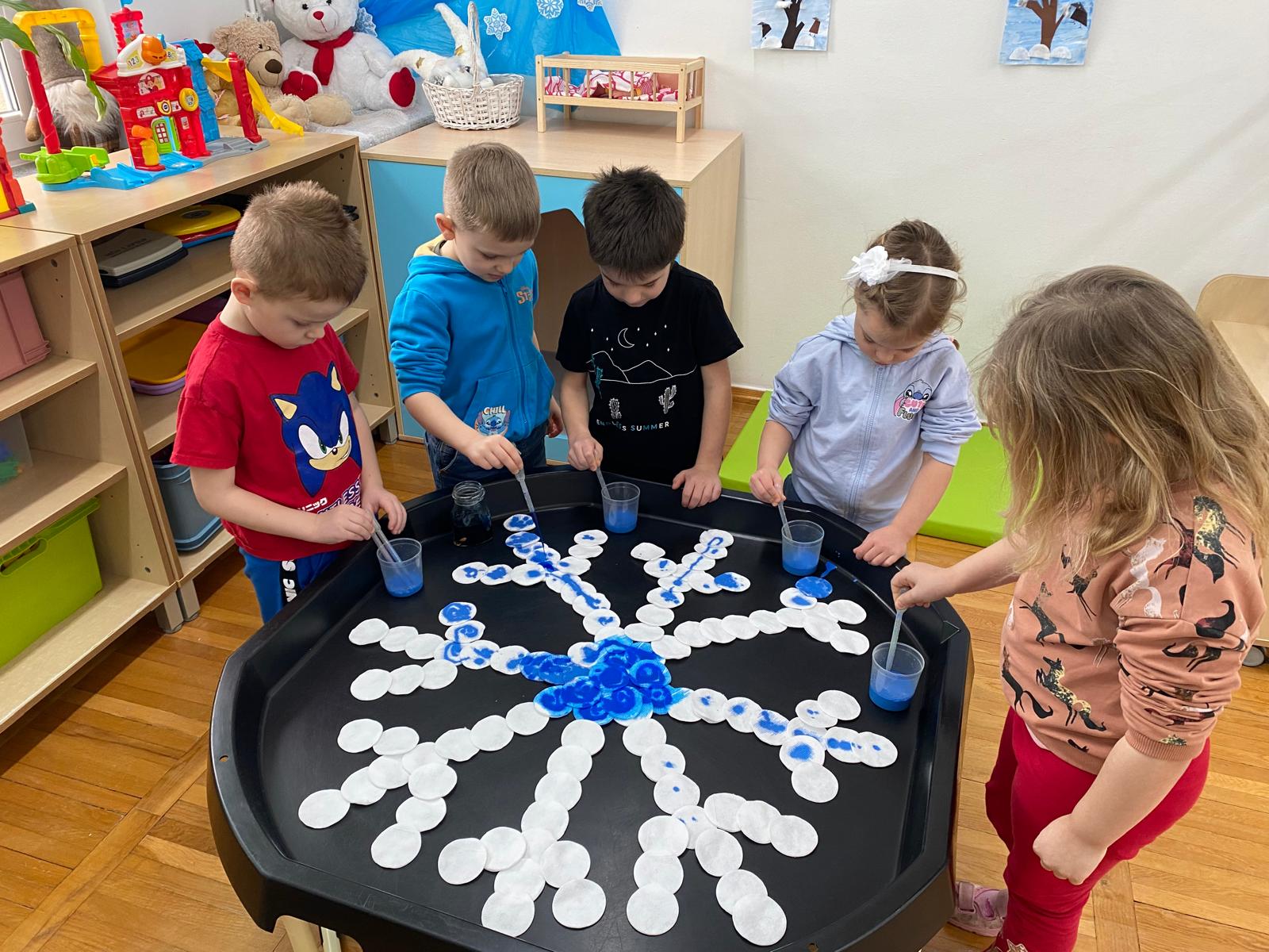  Dzieci stoją przy stoliku