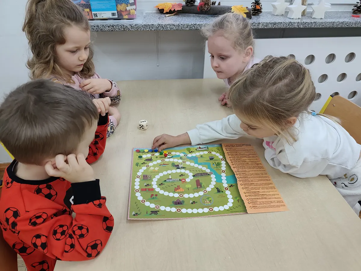  Dzieci siedzą przy stole,...